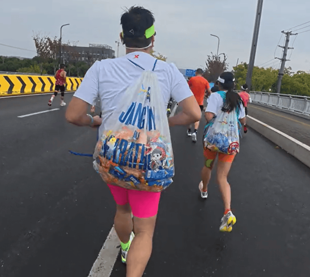 苏州马拉松一男一女将给选手的免费零食打包“负重”奔跑?主办方回应